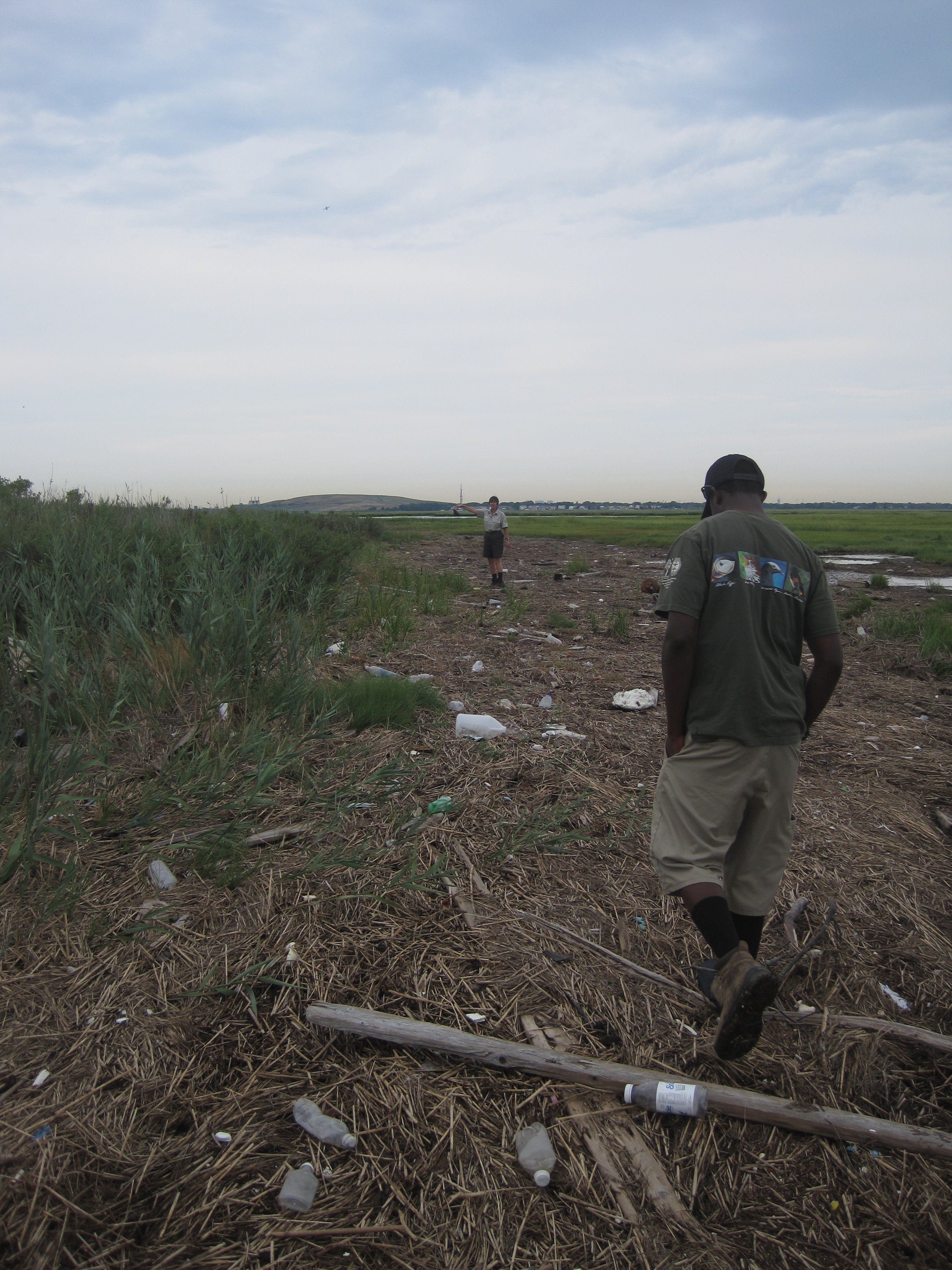 Staff walk through the marsh assessing damage from a recent storm