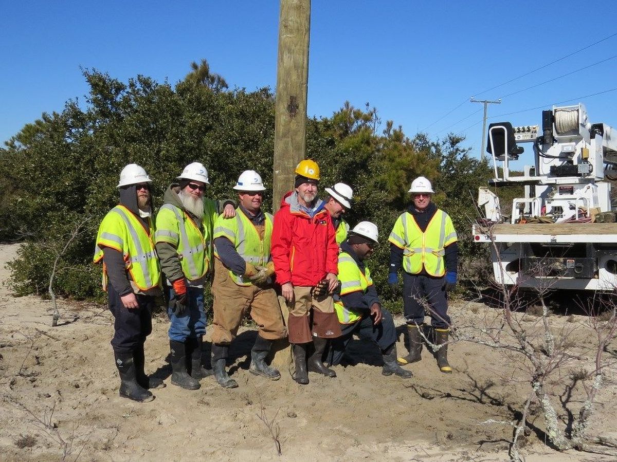 Refuge volunteer Reese Lukei, in the red jacket, poses with a crew from Dominion Virginia Power after they installed an osprey platform at Back Bay National Wildlife Refuge in Virginia.