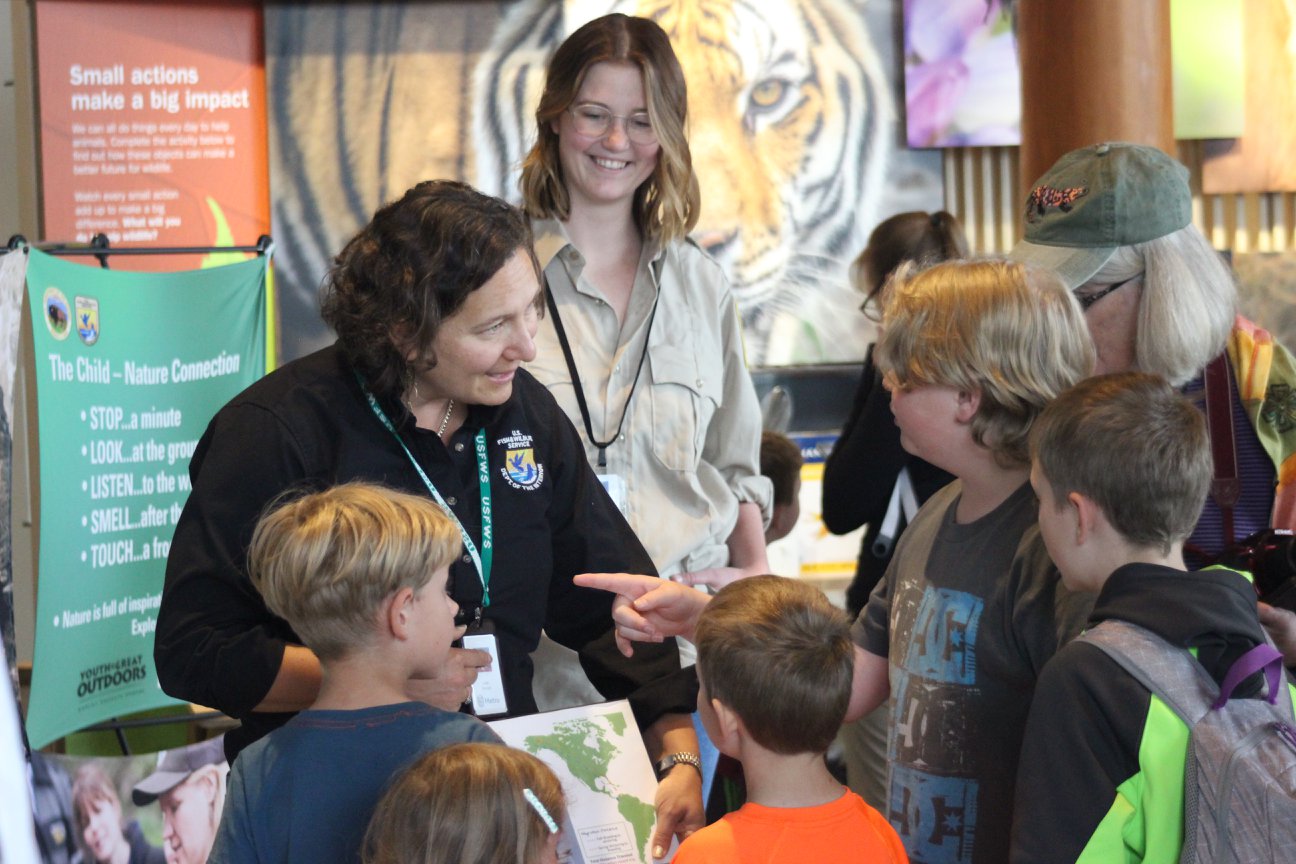 USFWS employee and ODFW employee talking with visitors at the Oregon zoo