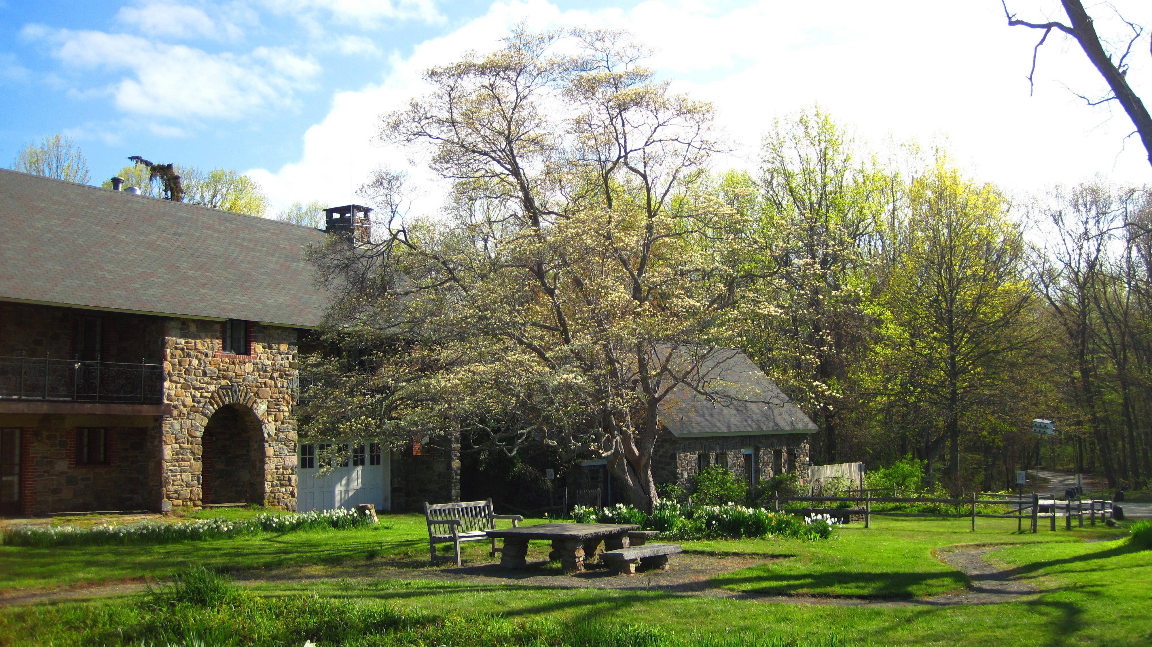 The refuge headquarters building at the Salt Meadow Unit, also know as the Lape-Read House, surrounded by trees and grass showing off their vibrant spring colors.
