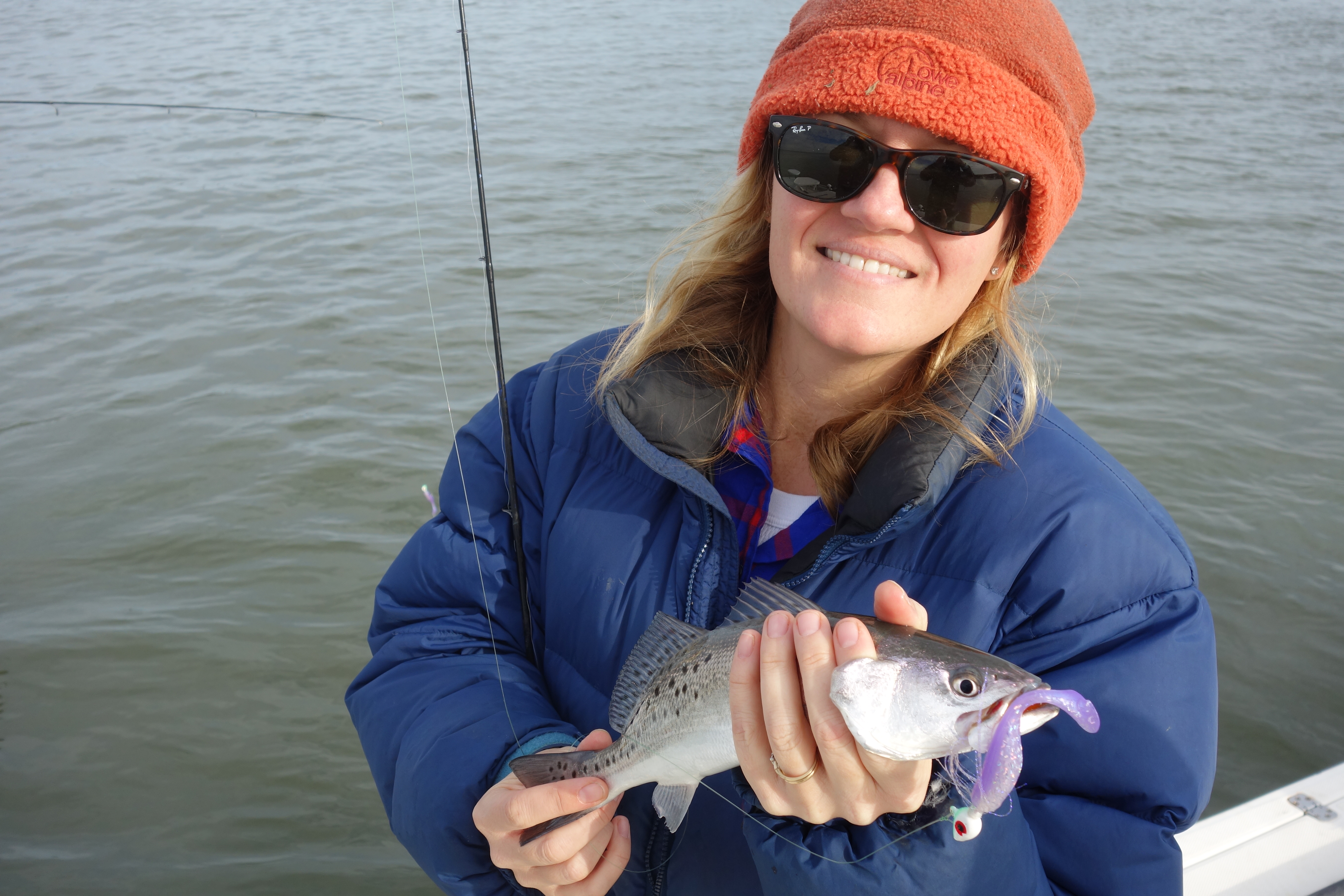Woman holds a sea trout she's caught as she's fishing in the estuary at Cape Romain NWR