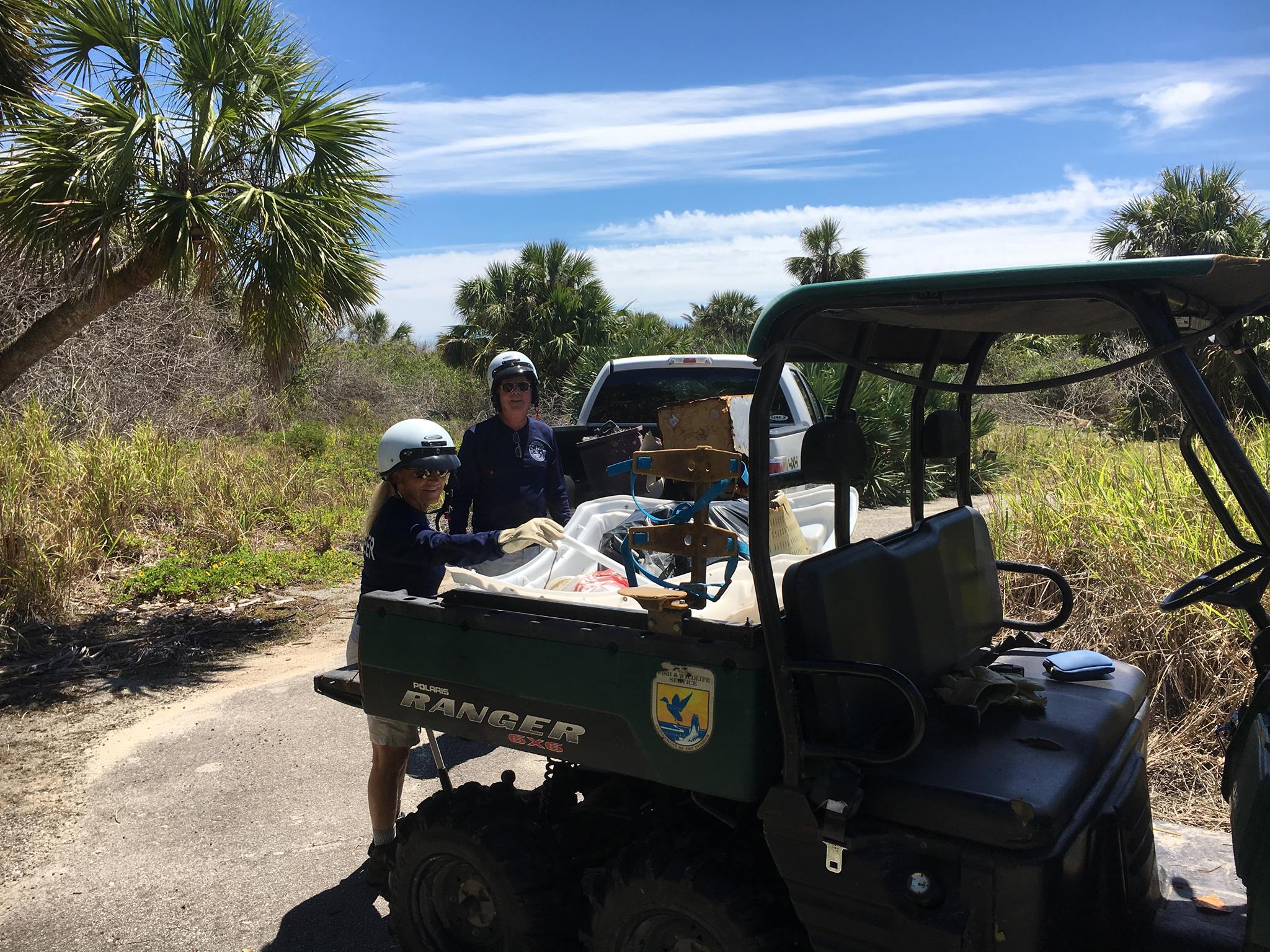 An image of volunteers collecting litter and placing it in an OHV.
