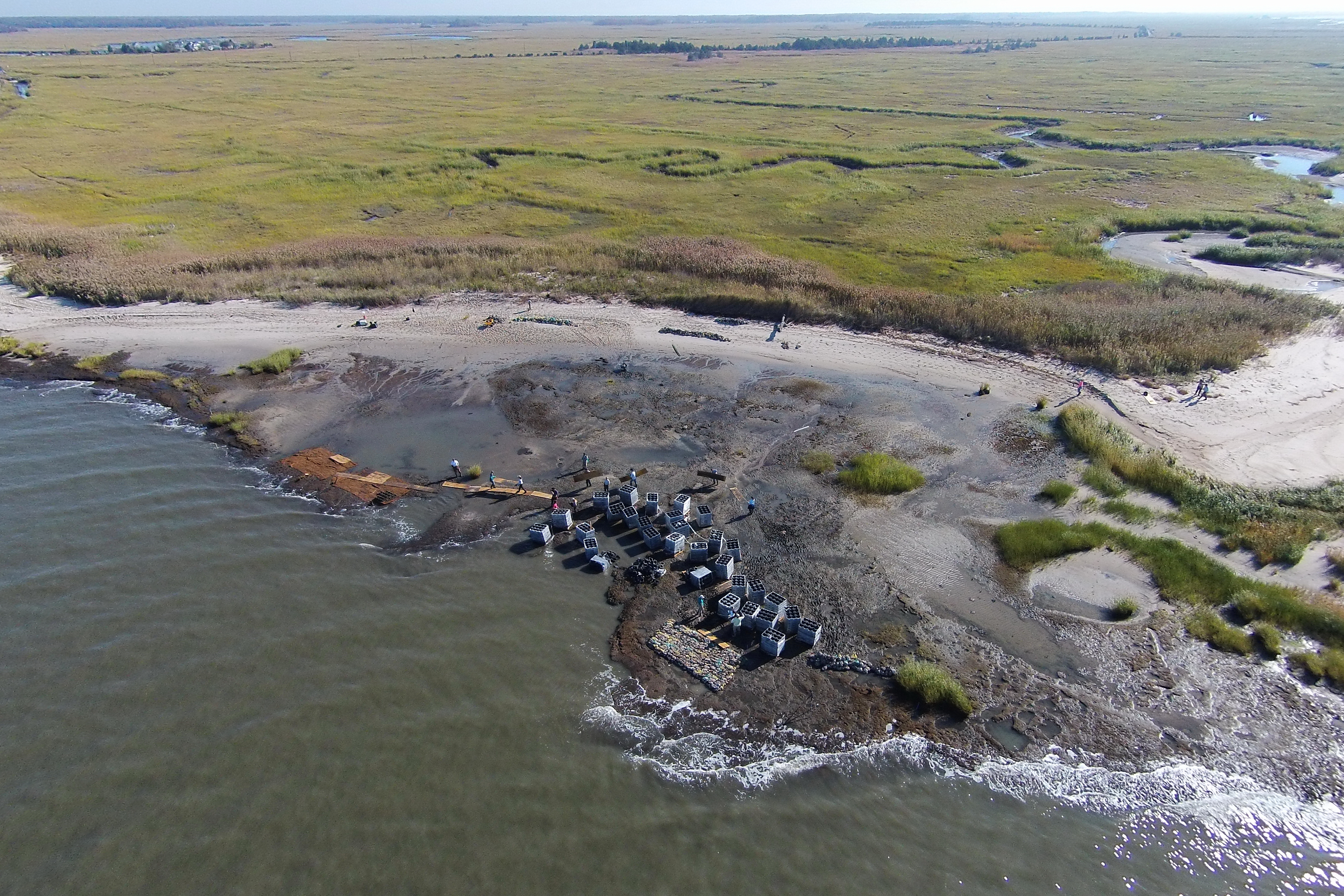 Aerial photo of coastline and people preparing to install an oyster reef 