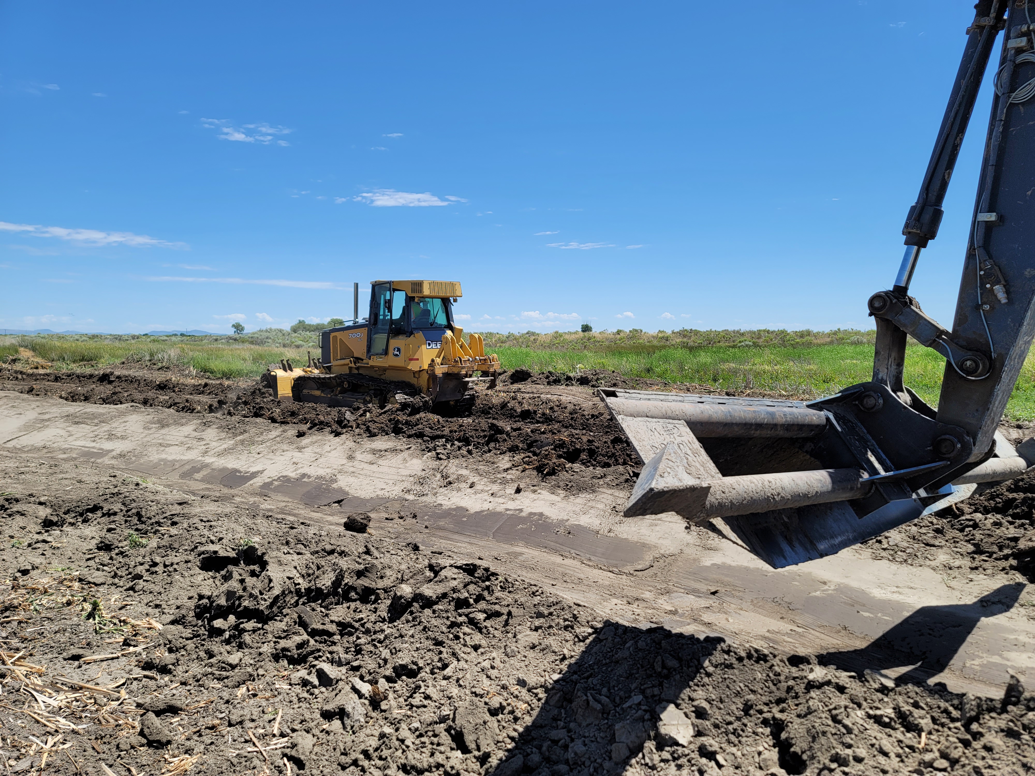 Heavy machinery dredges and clears a path at Idaho refuge on clear day