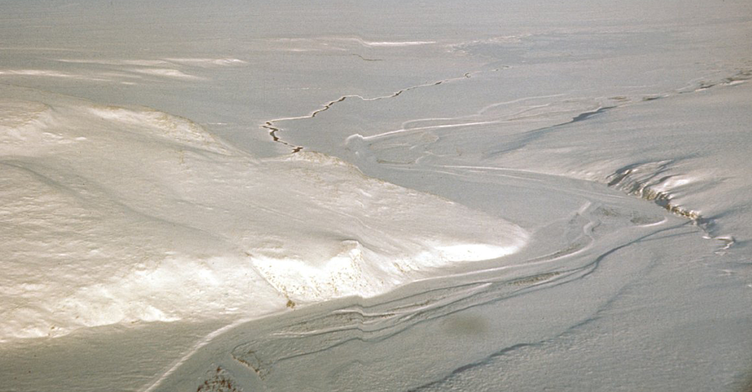 a snow scene showing topography including hills and a river from an aerial view