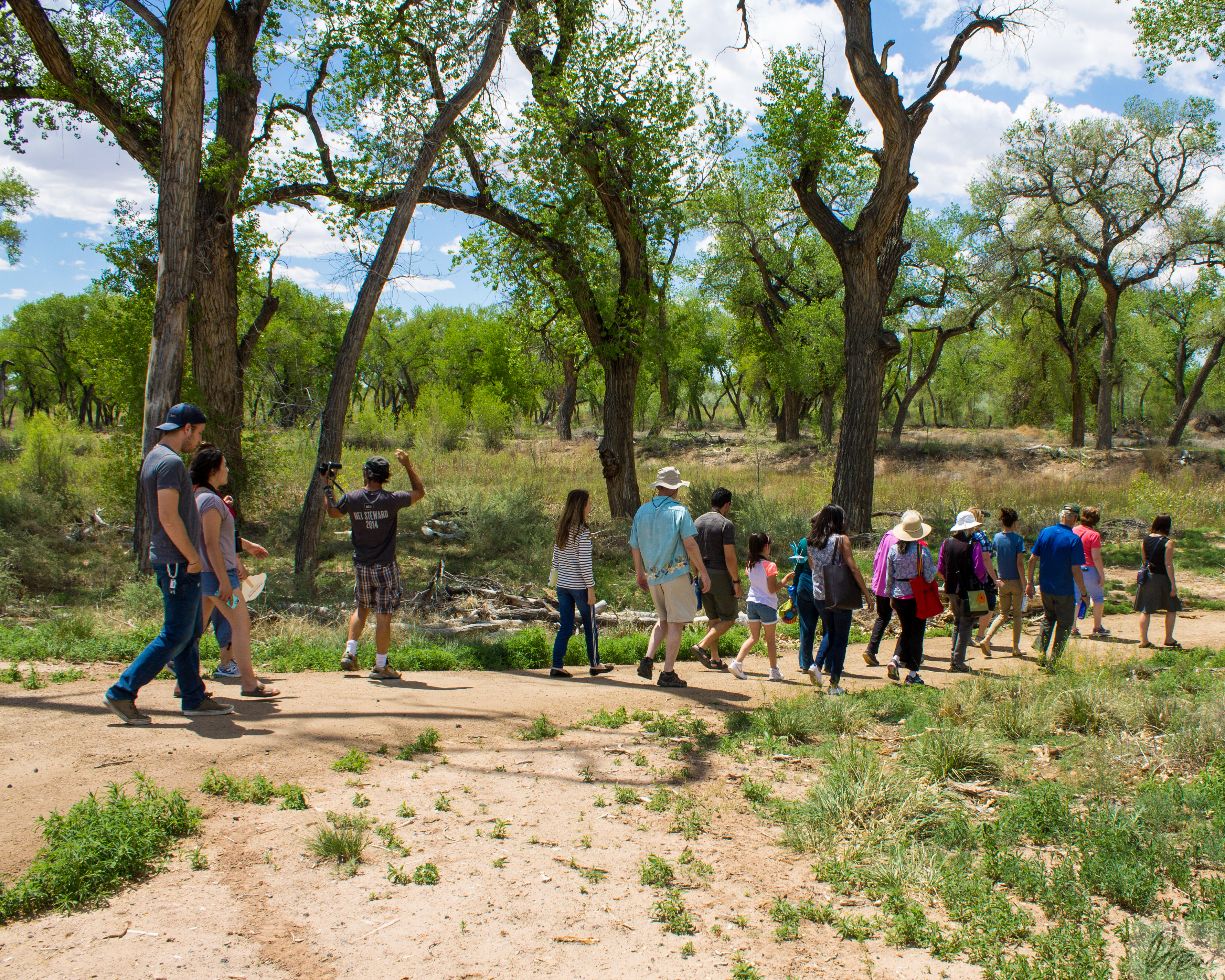 A group of school-age kids walking along a path in a dry environment