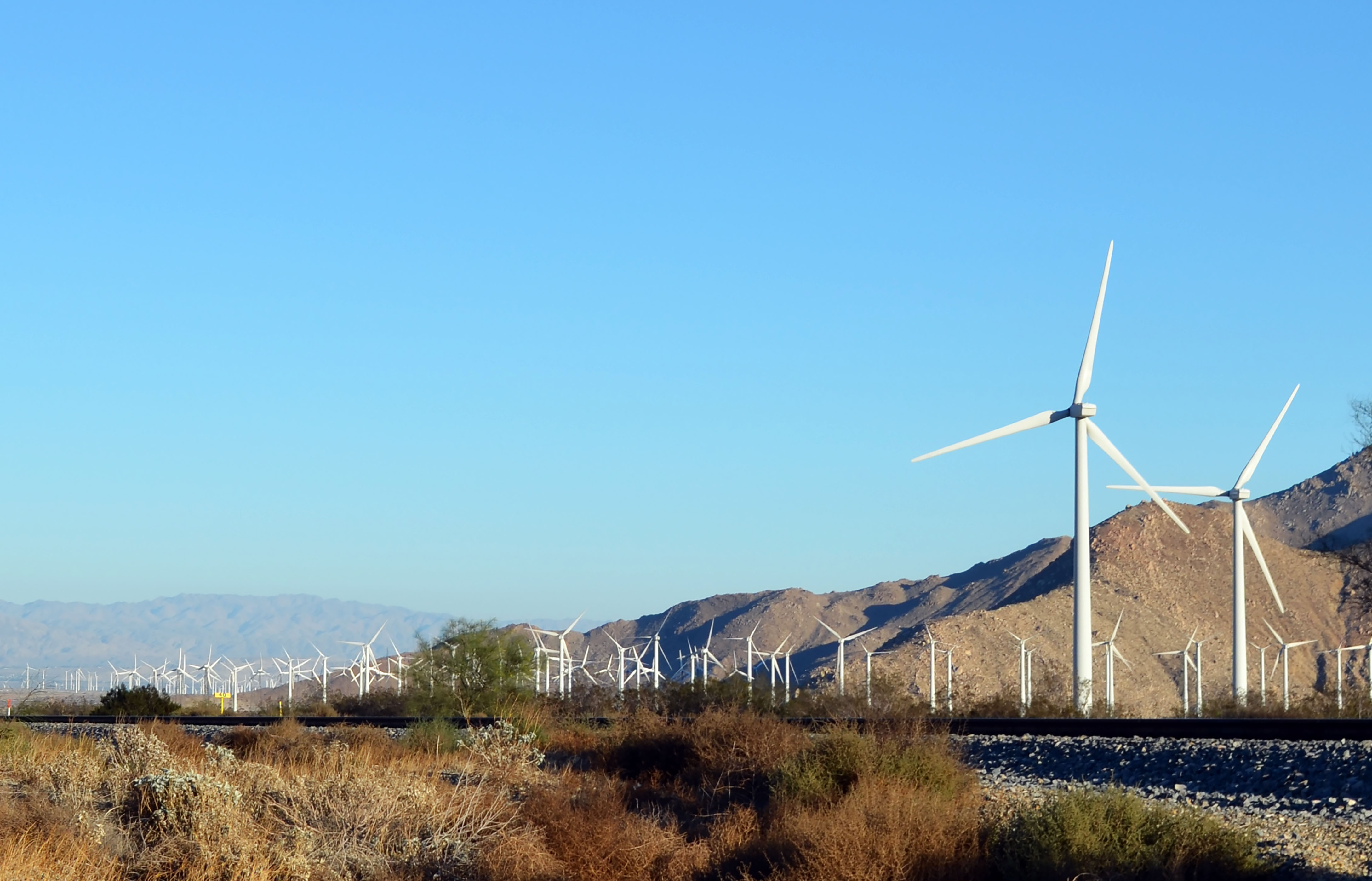 Wind farms running parallel to mountain range.