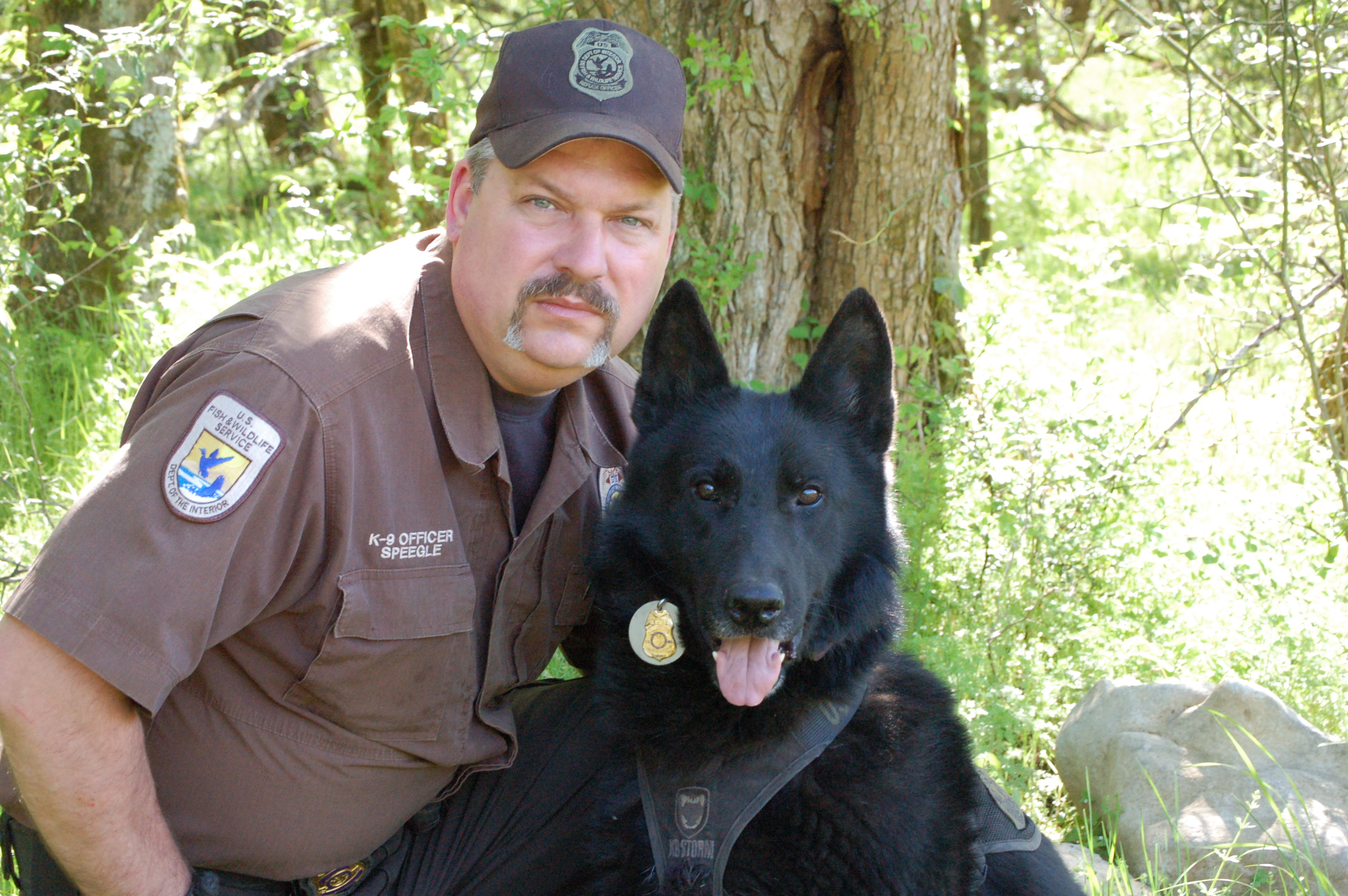 man in uniform with black dog 