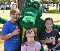 Alligator mascot poses with three girls at event