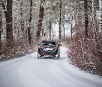 A vehicle drives a snow covered auto tour route