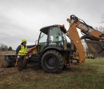 Backhoe tractor instructor teaches student about tractor