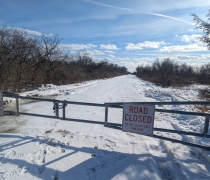 Image of closed gate over snowy road