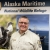 Man stands in front of mural with birds and the words Alaska Maritime National Wildlife Refuge