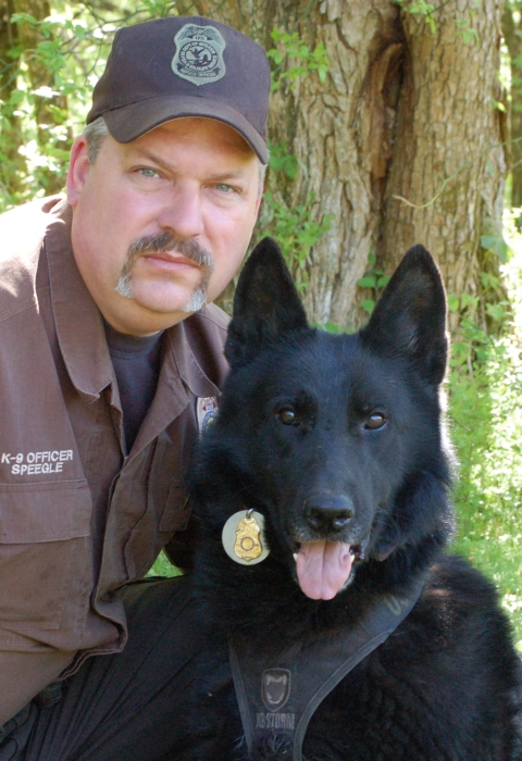 man in uniform with black dog 