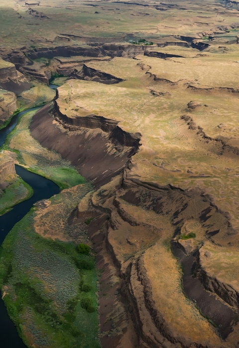 A river winds through a heavily channeled canyon