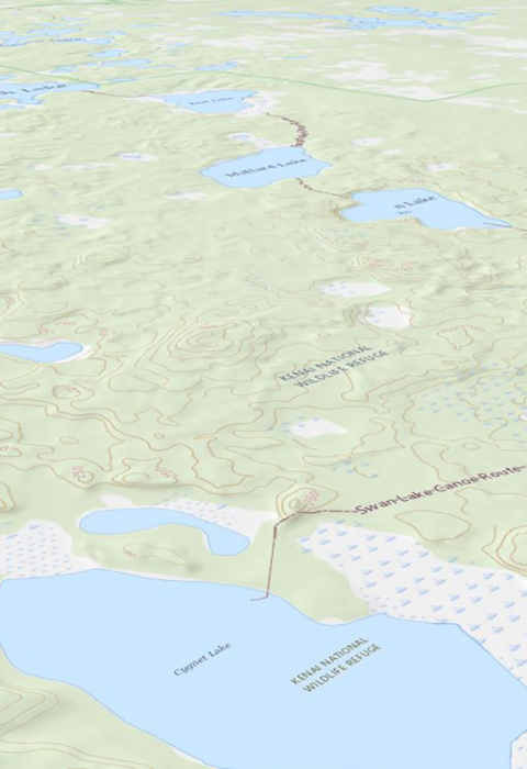 Off nadir view facing north east of a digital USGS topographic map displaying Swan Lake Alaska and surrounding water bodies with canoe trails marked on the map. 