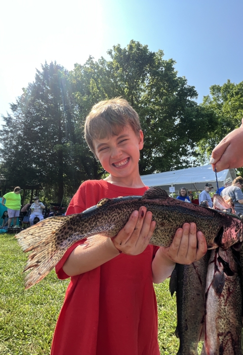 Photo of young angler holding up the fish he caught during the Wolf Creek National Fish Hatchery Catch-a-Rainbow Derby
