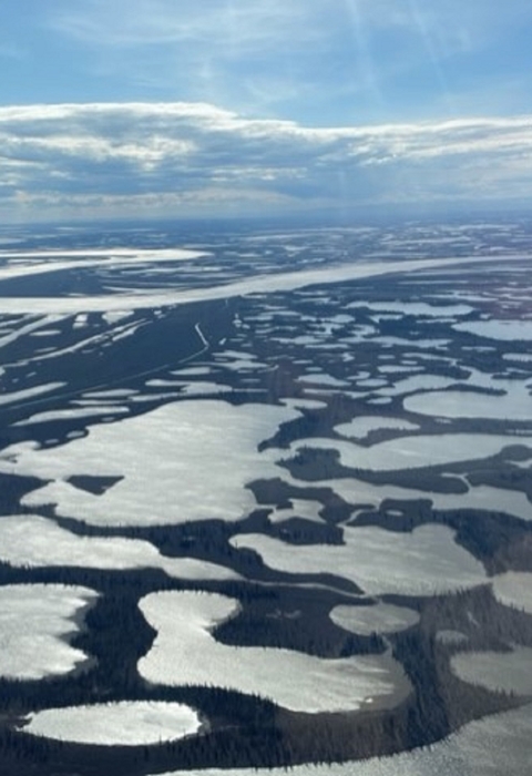 view from an airplane of wetlands and a large river across the landscape