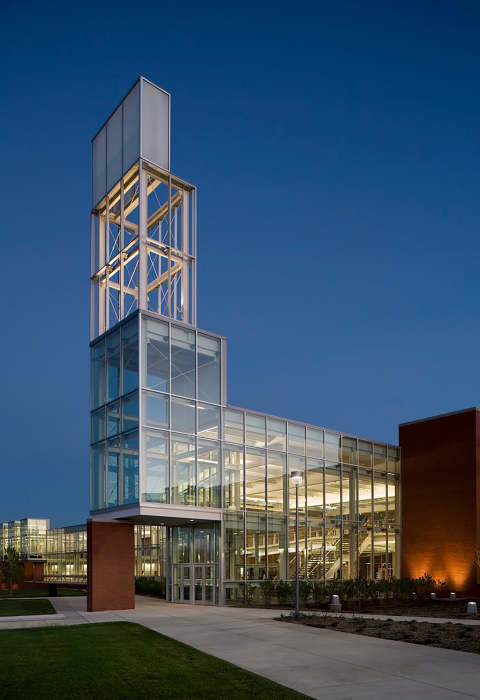 A building on a college campus illuminated by light at dusk