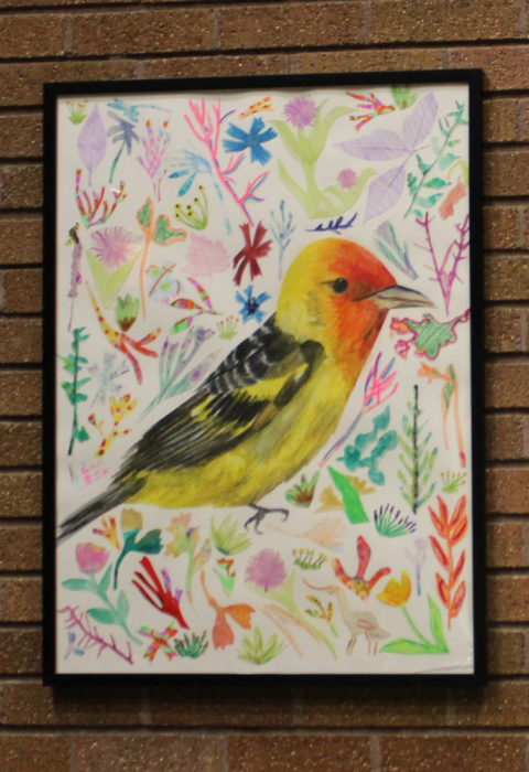 Two framed art pieces on a brick wall