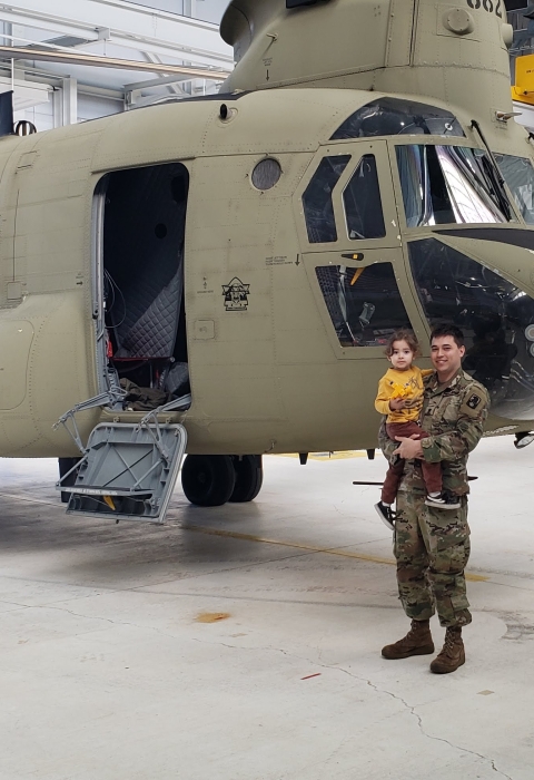 Story author, Addison Emerson, and his daughter pose in front of a Chinook helicopter.