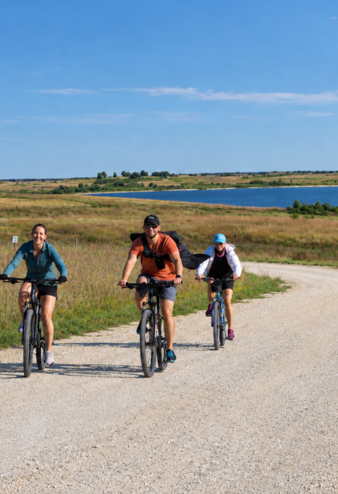 Three cyclists ride along the southern shore of Kirwin Reservoir