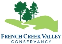 Logo of a white silhouette of a creek snaking through green hills, with three tree silhouettes in the background. Text says "French Creek Valley Conservancy".