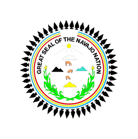 a circular seal that reads, Great Seal of The Navajo Nation with illustration graphics three mountains, a sun, three deers, two corn starks that are crossed by the lower part of it of the seal and Indian spears circling the outer boarder of the seal. 