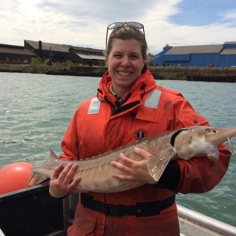employee holding a fish on a boat
