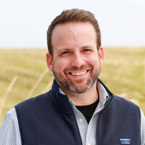 Smiling man in front of a field.
