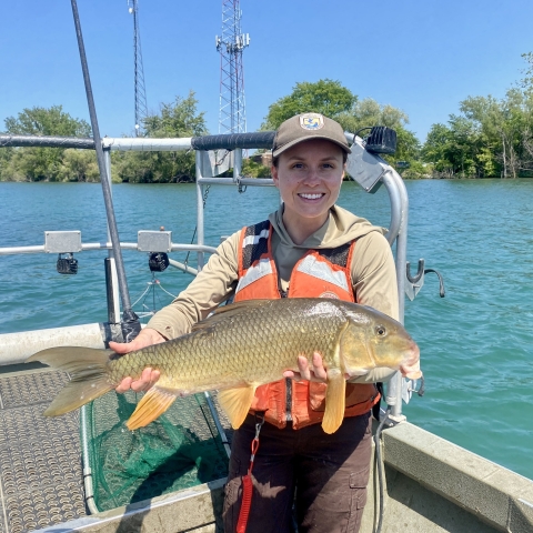 staff member holding a fish on a boat