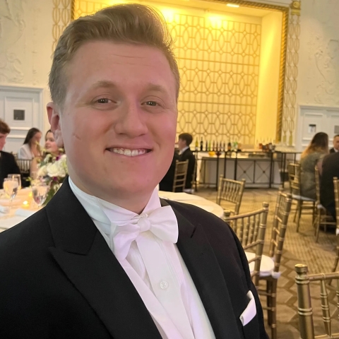 man in bow tie, formal wear at a dinner smiling at camera