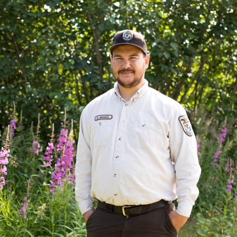 man in uniform with fireweed behind