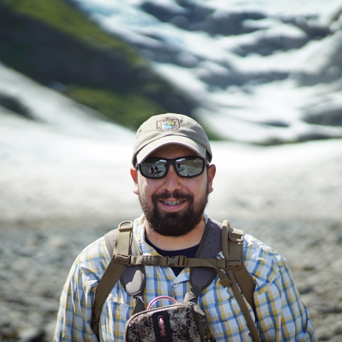 man in sunglasses in front of a glacier
