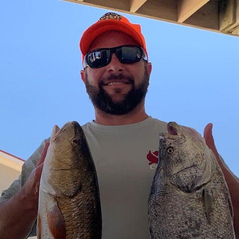 Eric Prowell holding two fish