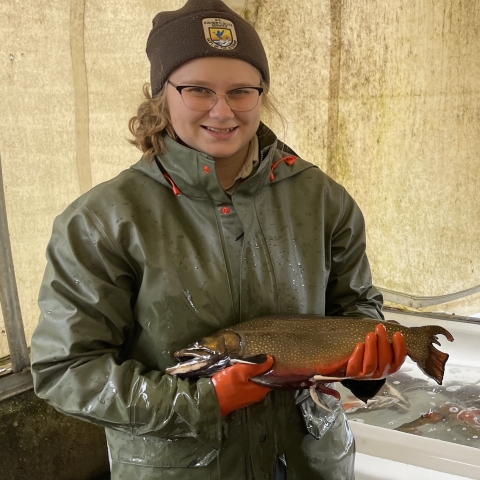 Biological science technician Rebekah holding a brook trout