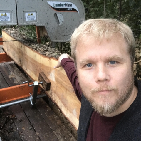 Man putting wood into a splitter