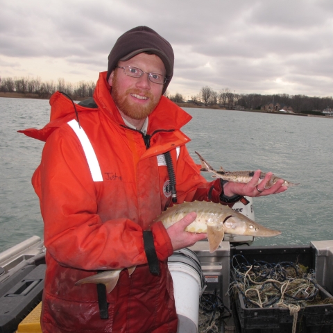 man in boat holding fish
