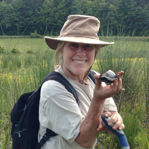 Lone person standing in a field, holding a turtle