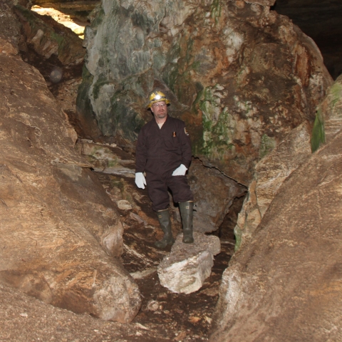 Rob standing in the rock shelter feature located between the east and west entrances to Key Cave