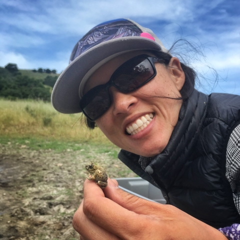 person smiling and holding a small toad 