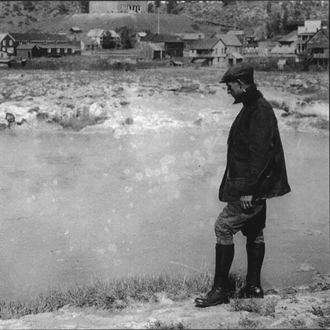 John Dingell standing on edge of pond