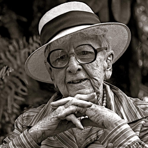 Up-close image of Marjory Stoneman Douglas - woman wearing hat with glasses and hand entwined