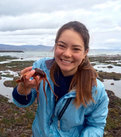 A woman in a blue jacket holding a small octopus