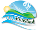 Logo that contains green hills in front of a blue sunny sky, full of birds and a hot air balloon. Text says "Visit Crawford".