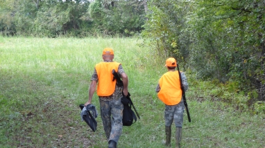 Father and son walk through a field during the youth deer hunt at Santee NWR. 