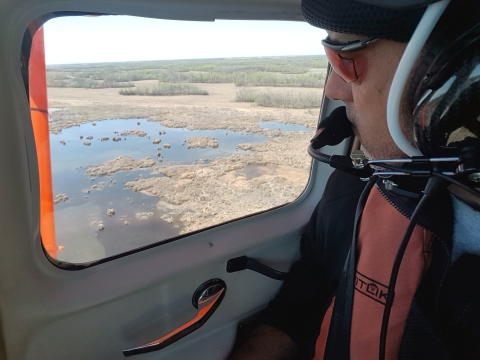 Man looking out a plane window. Jeff Drahota counting ducks in the Yorkton, SK area.