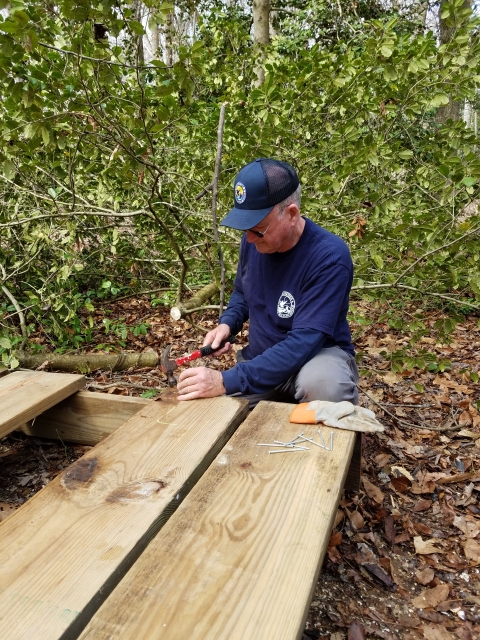 A volunteer helps build a well cover