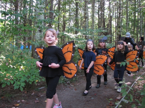 A groups of children dressed in monarch butterfly costumes participate in a day of learning at Rachel Carson National Wildlife Refuge. 