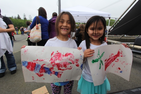 Two youth displaying their fish prints at Makah NFH Community Fishing Day 